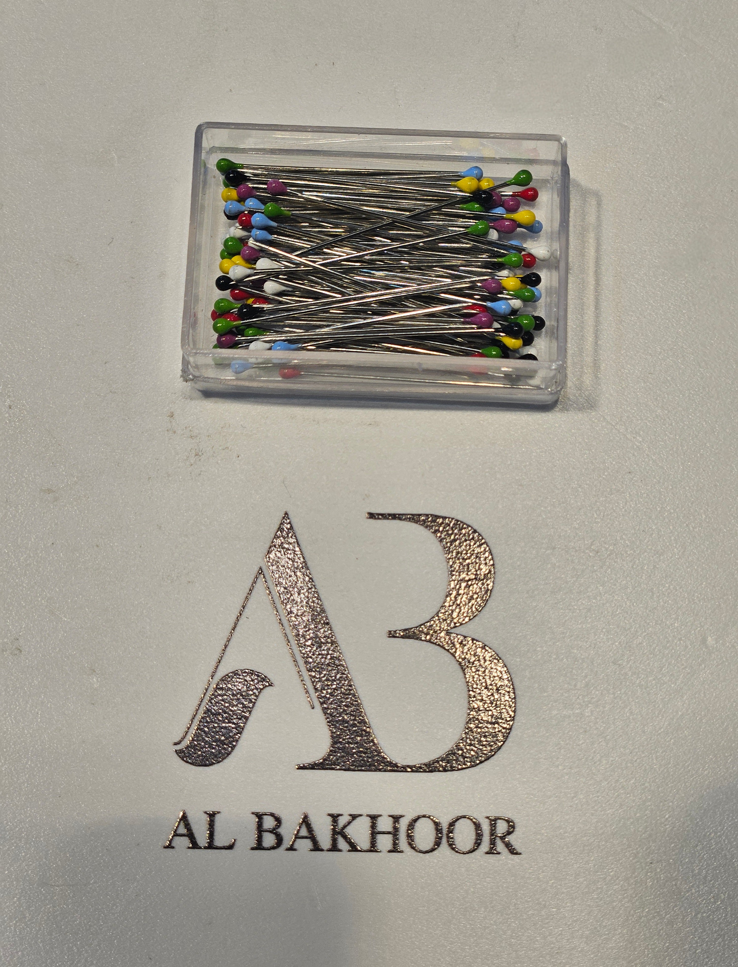 Box of coloured pins for hijab
